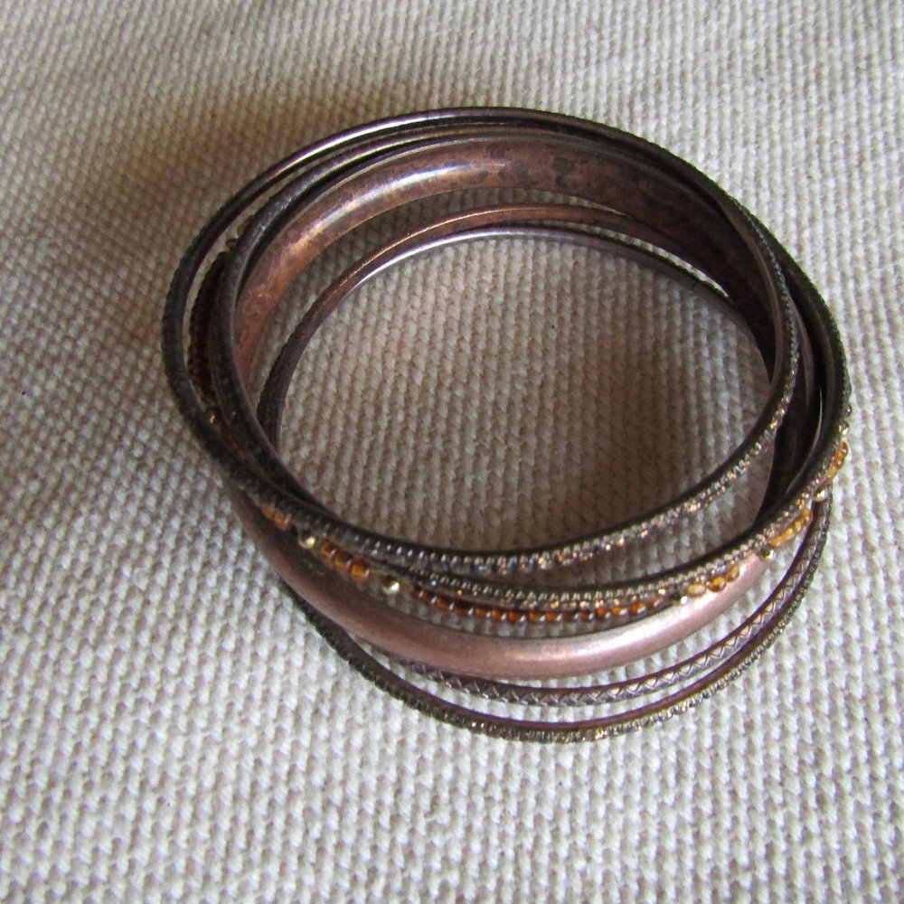 Set of antique brass and copper bangle bracelets with amber accents